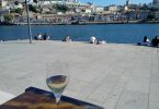 White wine glass on table in front of Porto's river with view to the other side