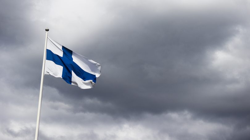 Finnish flag in front of dark clouds