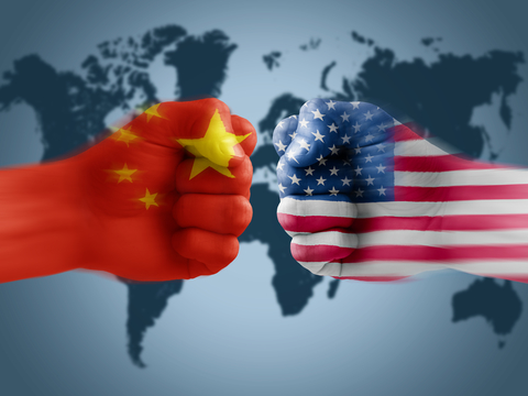 Chinese and US fist confronting each other in front of world map
